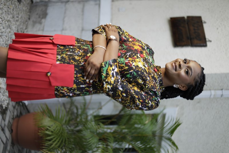 Abstract print top and red pleated skirt close-up side profile by best tailor Enugu