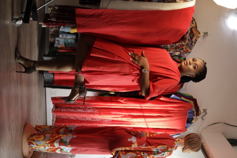 Red babydoll puff-sleeve dress playful pose in studio by fashion designer Enugu