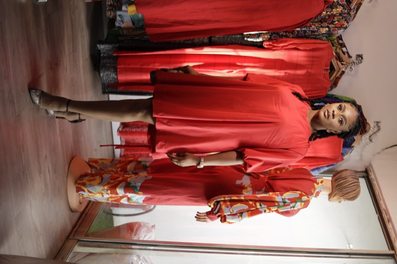 Red babydoll puff-sleeve dress standing in fashion studio by Prom G Fashion