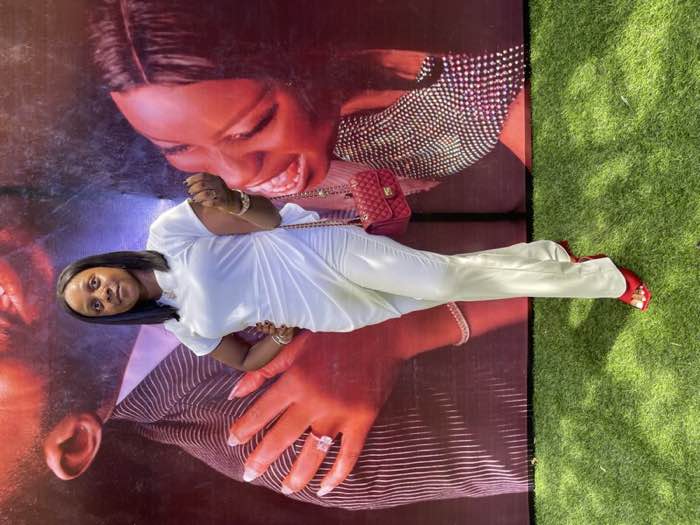 White satin draped jumpsuit with red heels at event by fashion designer Enugu