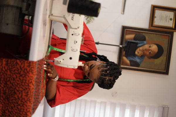 Prom G Fashion designer sewing Ankara fabric at workshop in Enugu