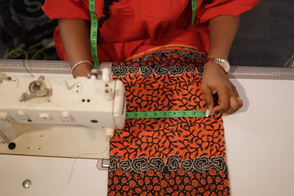 Close-up of Ankara fabric being sewn on machine at Prom G Fashion Enugu