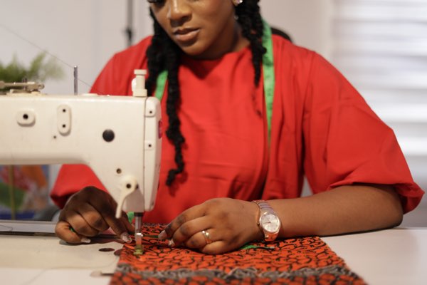 Expert tailor hand-crafting premium Ankara outfit at Prom G Fashion Enugu